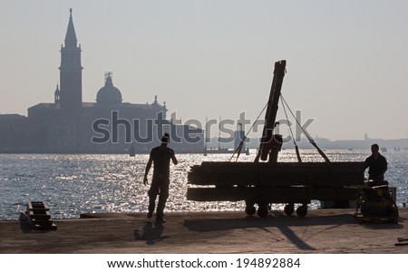 VENICE, ITALY - MARCH 14, 2014: Repair on the waterfront and silhouette of San Giorgio Maggiore church.