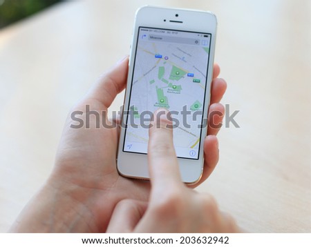 MINSK, BELARUS - JULY 05, 2014: Woman holding on Google Maps application on new black Apple iPhone 5S. Google Maps is most popular mapping service for mobile provided by Google.