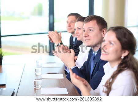 Image of business colleagues applauding in the end of the conference sitting in a line