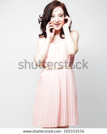 Woman in pink dress. Curly hair and pretty smile.