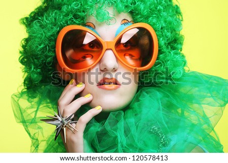Happy young  woman with green hair and carnaval glasses