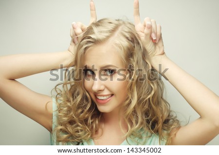 Funny portrait of beauty girl (she is making horns or big bunny ears from her hands), isolated on white