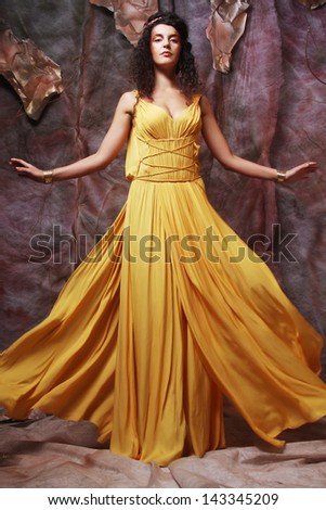 beautiful young brunette woman wearing yellow evening dress