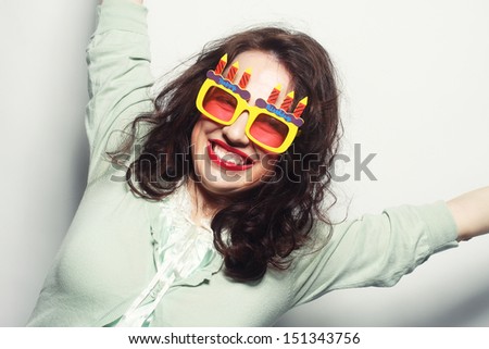 Positive energy portrait of happy funny woman with bright holiday glasses