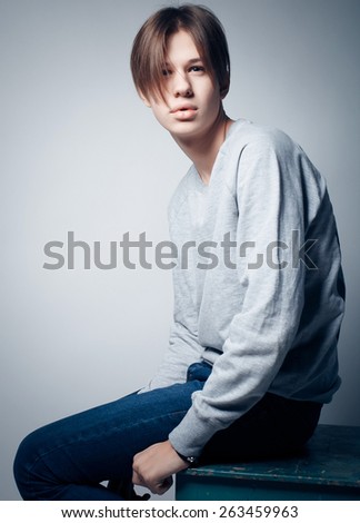 A young teenage boy being photographed in a studio.