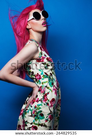 Beautiful fashion model  with pink hair and make-up wearing big sunglasses