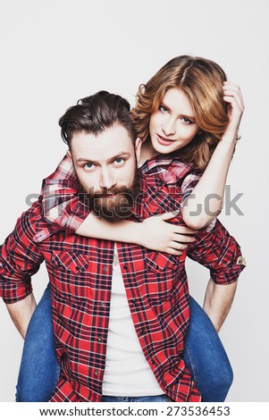 life style, happiness and people concept: Happy loving couple. Young man piggybacking his girlfriend. Studio shot over white background.Special Fashionable toning photos.