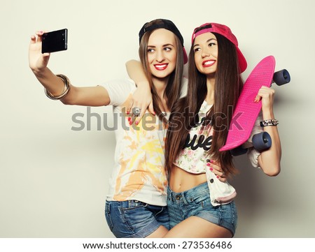 Sporty girlfriends standing having fun together. Beautiful women making selfie.Positive  emotion. White background.