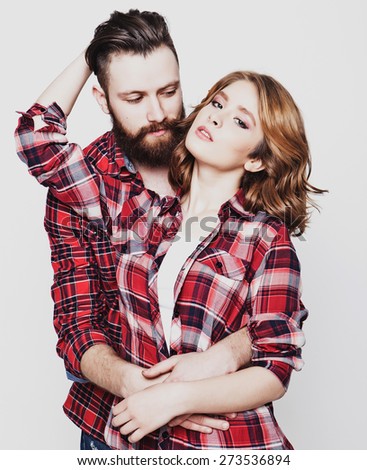 life style, happiness and people concept: Hipster couple. Beautiful young loving couple pposing  while standing against white  background.
