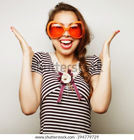 Party image. Playful young woman with big party glasses and crown. Ready for good time.