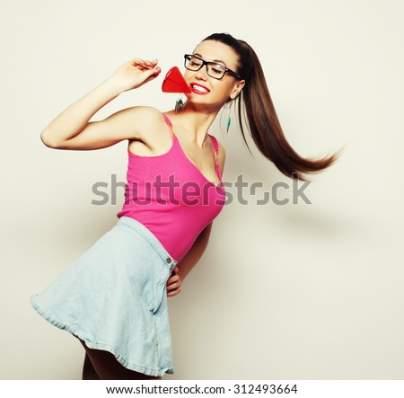 Young glamour girl holding candy and pulls his hair
