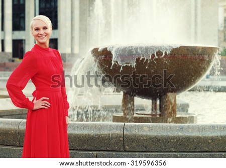 Fashionable young blond woman wearing red dress, summer day