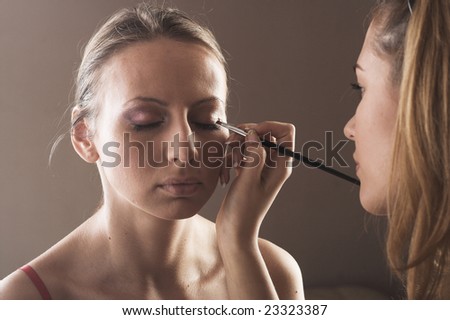 Close-up studio portrit of a makeup artist at work