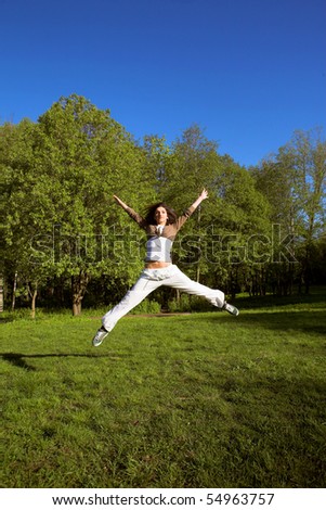 slim shaped beautiful girl jumping in park