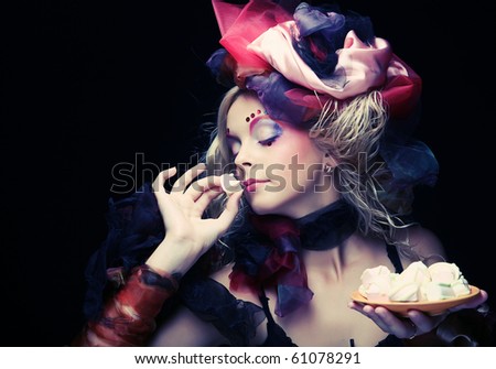 young woman with creative make-up in doll style with cake.