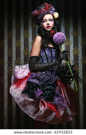 young woman with creative make-up in doll style with flower