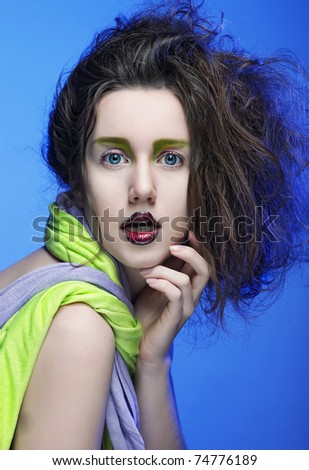 beautiful young woman with bright make-up over blue background