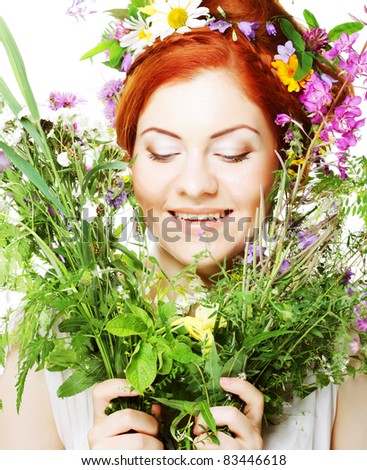 model with large hairstyle and flowers in her hair and with bouquet flowers.