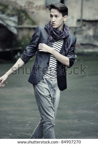 young fashion man in casual wear. posing on the street.