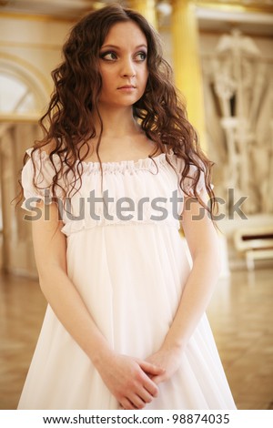 Portrait of a beautiful young victorian lady in white dress.Russian palace.