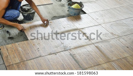 Construction worker tiling the floor.