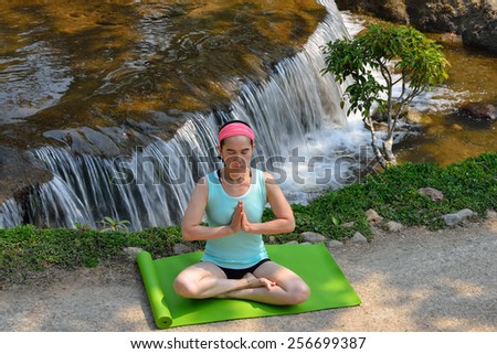 Middle aged woman doing yoga posture outdoor