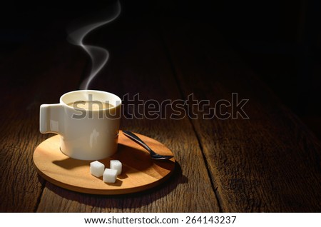 Cup of coffee with smoke and sugar cube on old wooden background,This photo is available without smoke