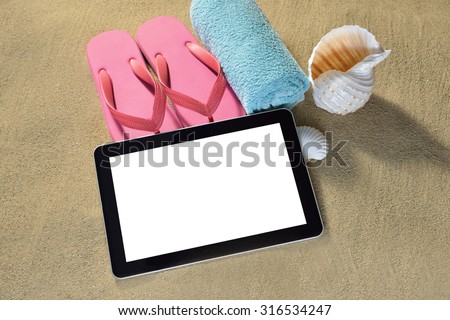 Tablet computer beach accessories and sea shells on the beach