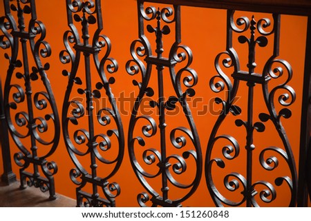 Black ornate wrought Iron railings with a bright background