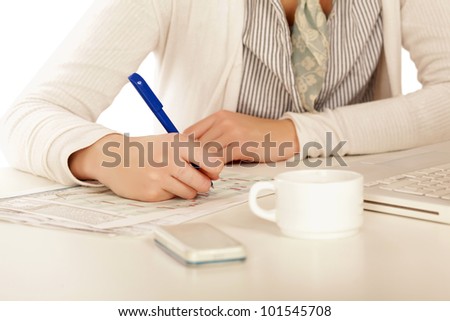 A woman at the desk writting on a paper, isolated on white