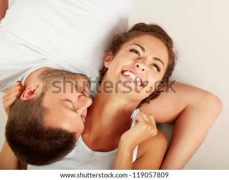 young lovely couple lying on the floor, isolated on white background