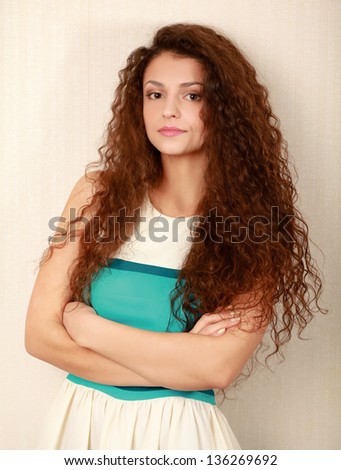 A young woman standing with folded arms, isolated on white background