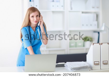 Medical doctor woman with computer and telephone.
