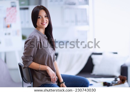 Young woman watching footage on film, standing near window