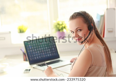 Woman with documents sitting on the desk and laptop