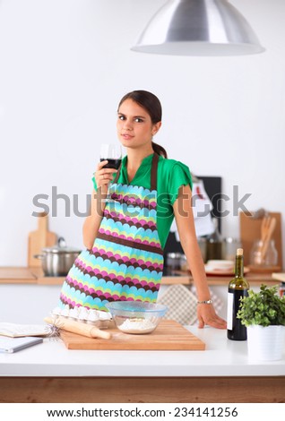 Woman with shopping bags in the kitchen at home, standing near desk