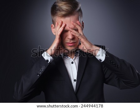 Executive man having head ache isolated on gray  background