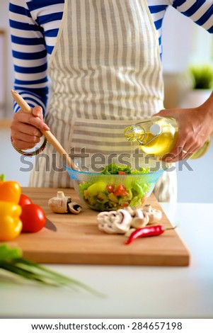 Young woman mixing fresh salad