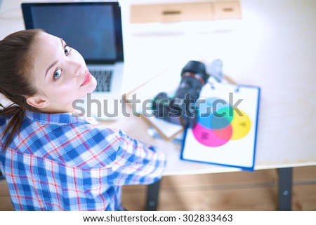Female photographer sitting on the desk with laptop