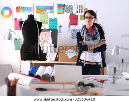 Beautiful fashion designer standing in studio