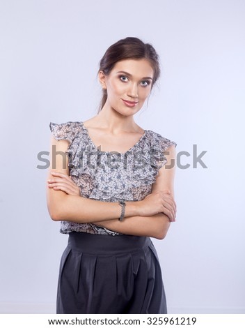 Full-body portrait of a happy business woman looking at camera with arms folded. Isolated on white background