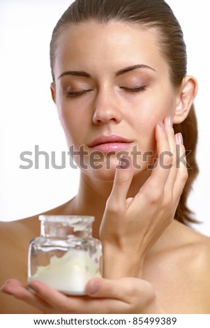 Yoga woman putting cream on her face Isolated on white background