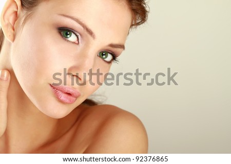 Young woman touching her face isolated on whire background
