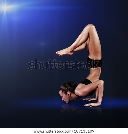 Young woman doing yoga on blue abstract background
