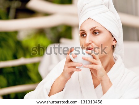 Pretty girl after bath  lost in thought with cup of coffee