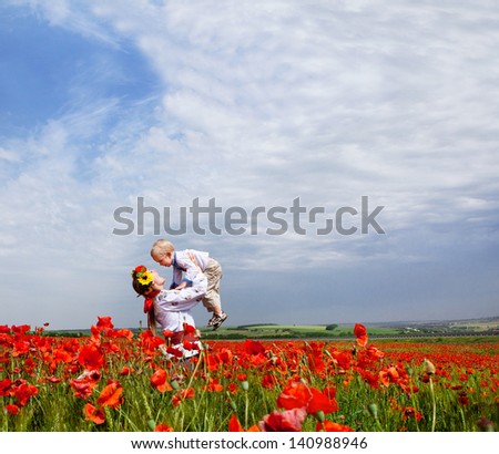 Happy mother and son on the poppies field. Ukrainian landscape