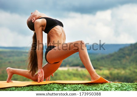 Slim athletic woman practicing yoga outdoor