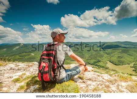 On the top of mountain. Man with backpack enjoyed with mountain view