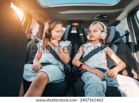 Similar – Image, Stock Photo Child sitting with headphones on a sofa with tablet computer looking frontally at night