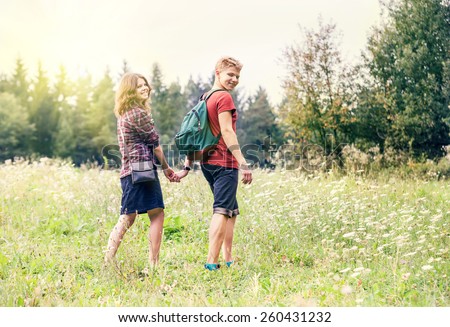 Young couple on the walk in summer forest